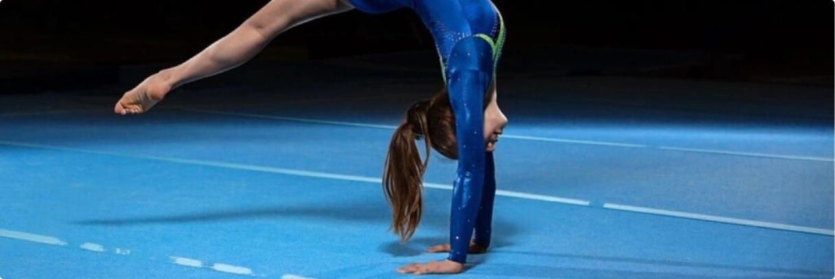 Gymnast doing hand stand on flooring