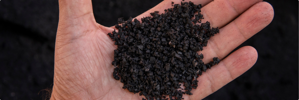 Persons hand holding recycled rubber chips